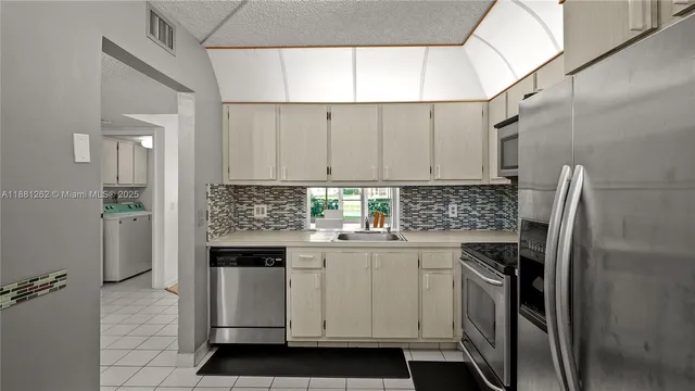 a kitchen with a sink cabinets and stainless steel appliances
