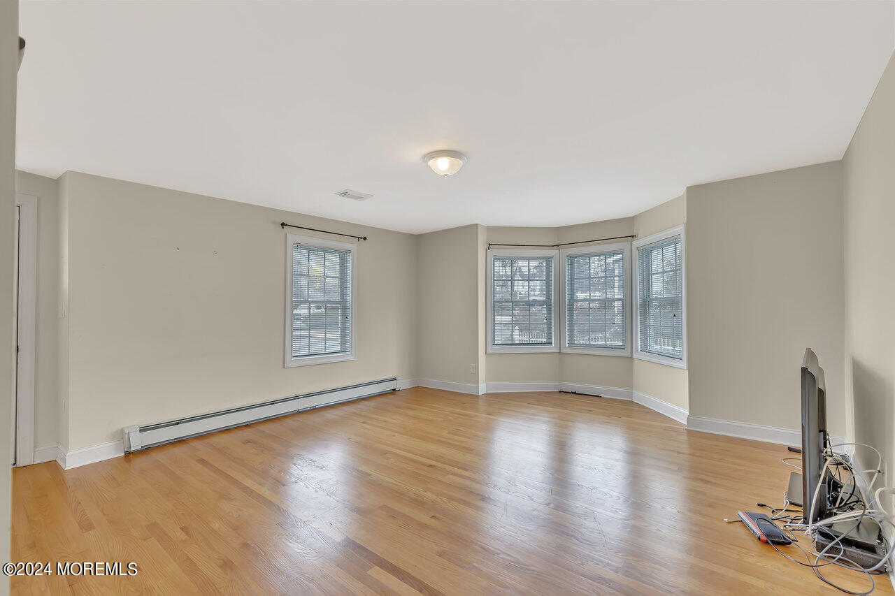 164 Jackson Street Matawan, NJ 07747 - Photo 5 of 26 a view of an empty room with wooden floor and a window