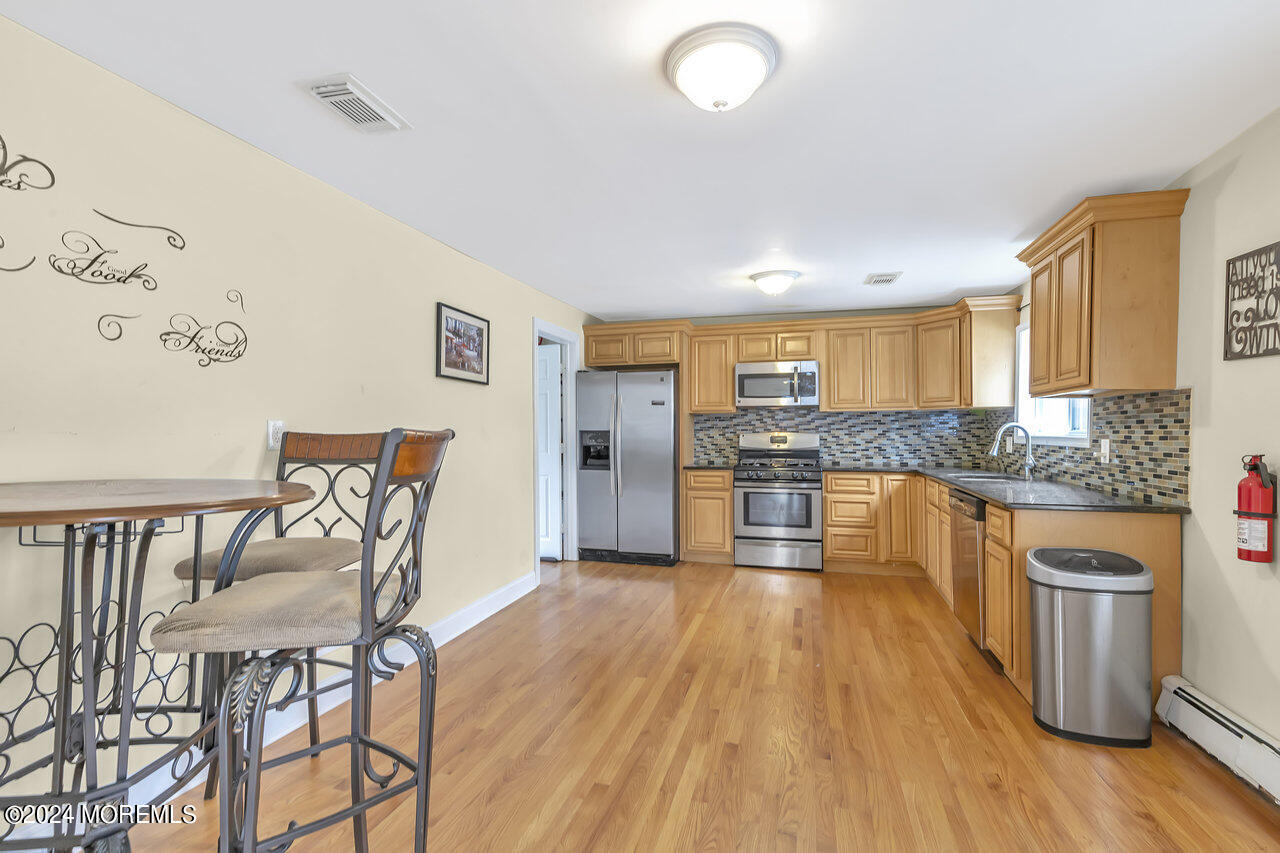 164 Jackson Street Matawan, NJ 07747 - Photo 10 of 26 a large kitchen with cabinets wooden floor and stainless steel appliances
