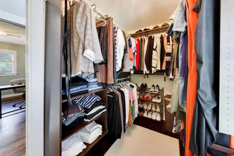 a view of walk in closet with clothes and shoes