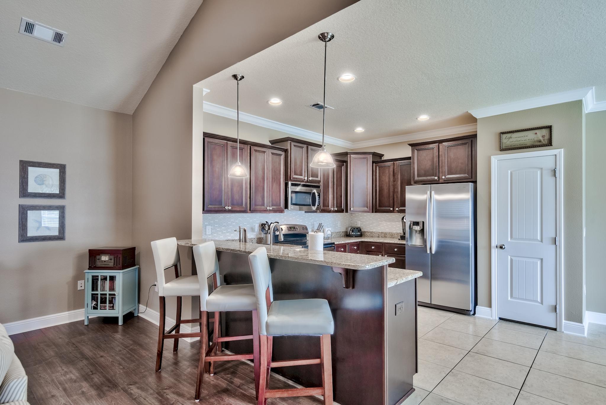 464 Pin Oak Loop Santa Rosa Beach, FL 32459 - Photo 10 of 44 a kitchen with refrigerator and chairs