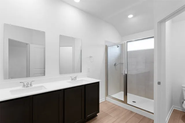 a bathroom with a double vanity sink mirror and shower