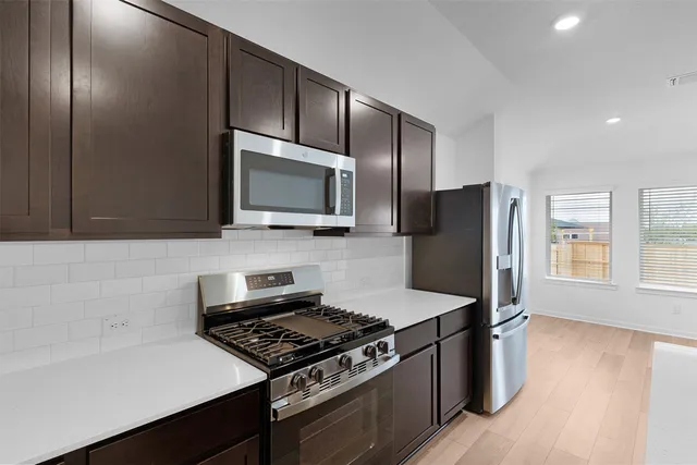 a kitchen with stainless steel appliances wooden cabinets and a stove top oven