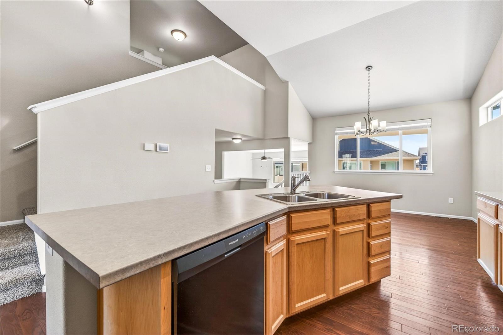 10436 17th Street Greeley, CO 80634 - Photo 4 of 18 a kitchen with sink cabinets and wooden floor