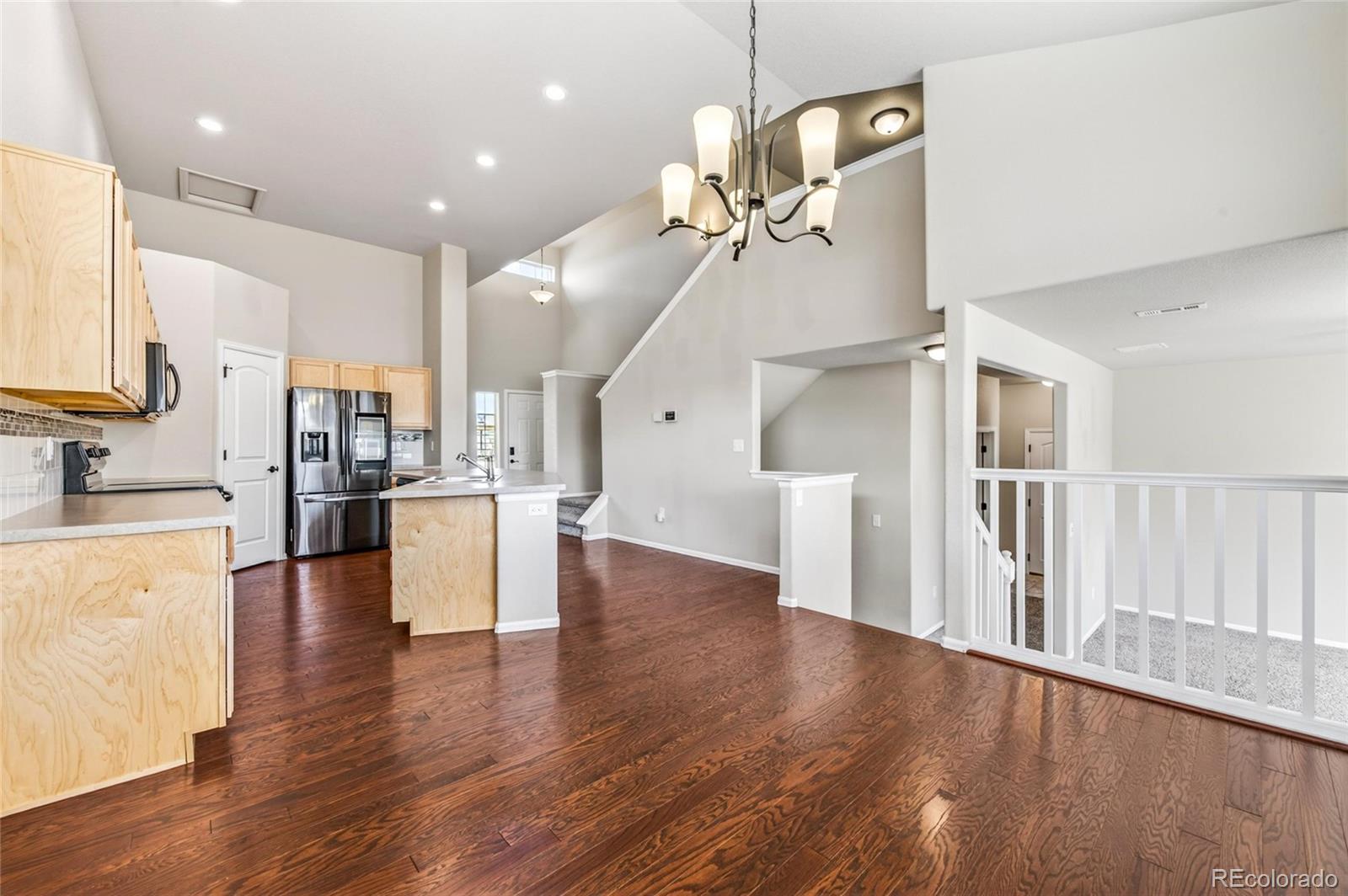 10436 17th Street Greeley, CO 80634 - Photo 5 of 18 a view of a kitchen with kitchen island stainless steel appliances wooden floor dining table and chairs