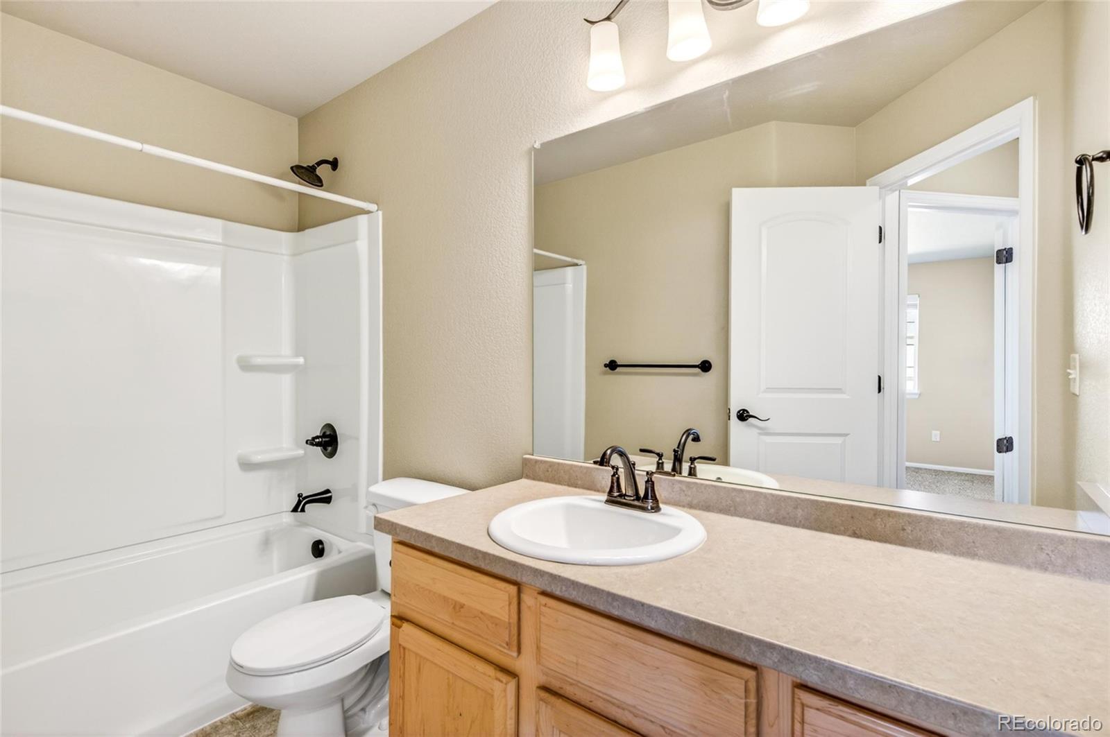 10436 17th Street Greeley, CO 80634 - Photo 7 of 18 a bathroom with a granite countertop sink a toilet and shower