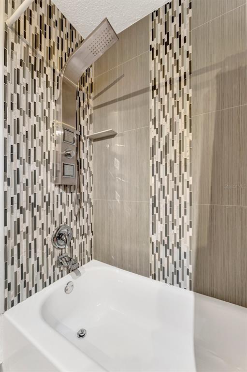 13300 Walsingham Road, Unit 56 Largo, FL 33774 - Photo 24 of 35 a bathroom with a bathtub and shower