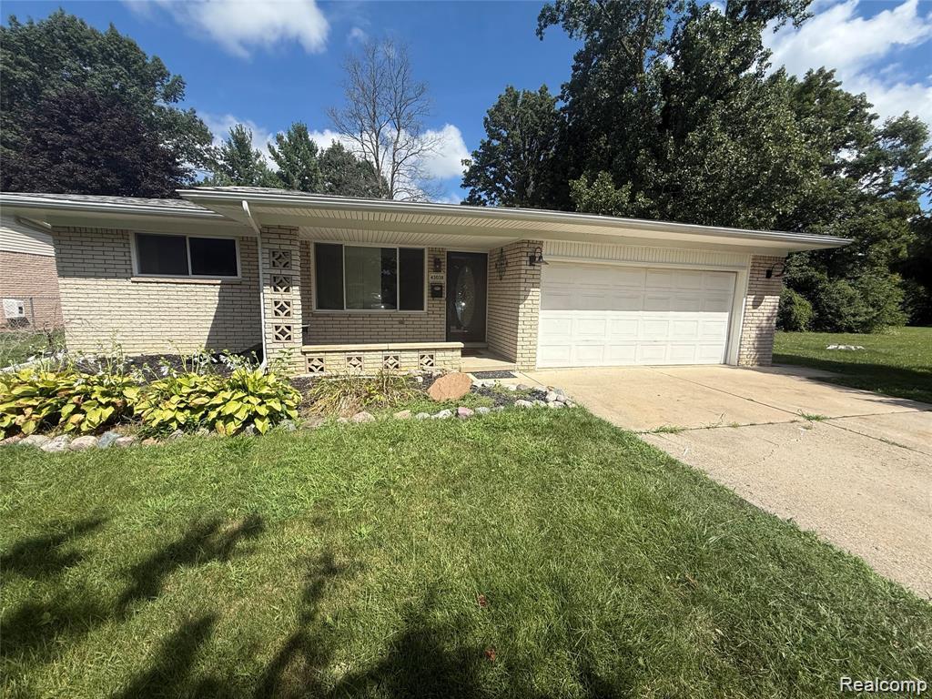43038 Hanford Road Canton, MI 48187 - Photo 1 of 36 Light-colored brick exterior featuring a covered entry, an attached two-car garage, and a concrete driveway