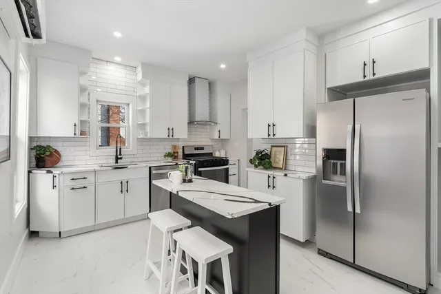 a kitchen with white cabinets and stainless steel appliances