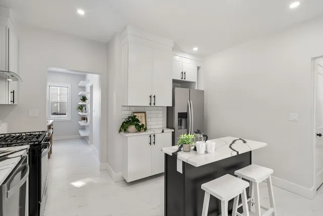 a kitchen with a sink and chairs