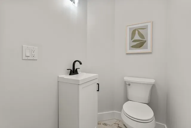 a white toilet sitting next to a bathroom sink