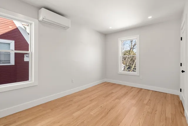 a view of empty room with window and wooden floor