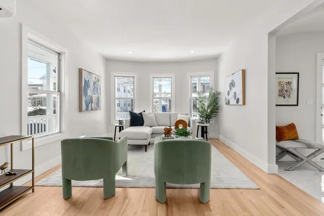 a living room with furniture and a potted plant next to a window
