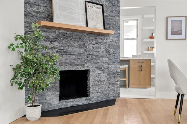 a living room with a fireplace and potted plant
