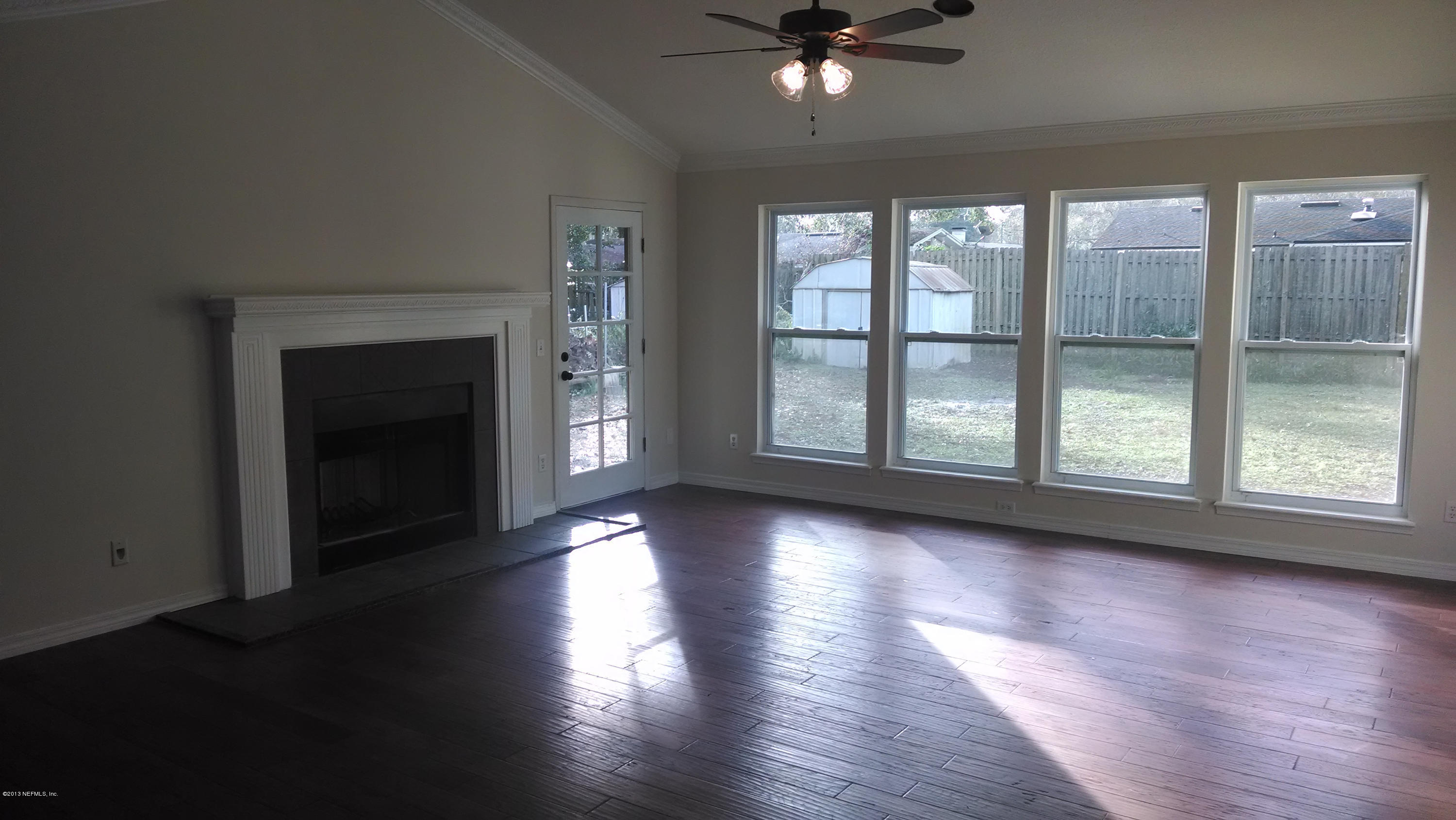 7030 St Augustine Road Jacksonville, FL 32217 - Photo 4 of 12 a view of an empty room with wooden floor and a window