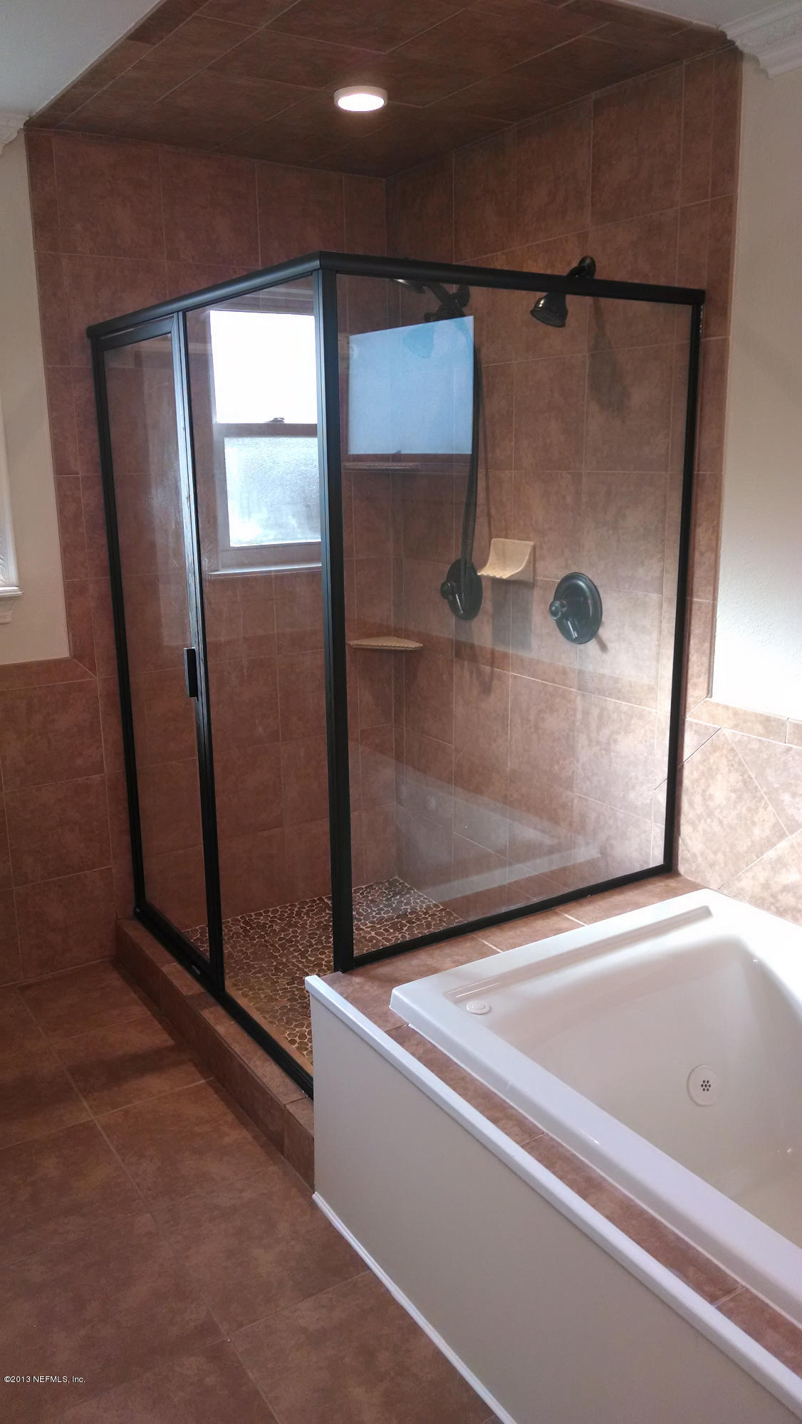 7030 St Augustine Road Jacksonville, FL 32217 - Photo 8 of 12 a bathroom with a bathtub and a shower