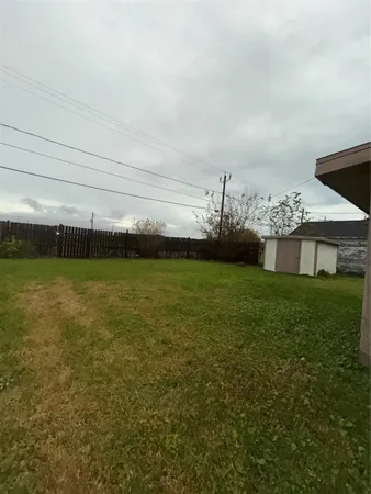 a view of a big room with a big yard and large trees