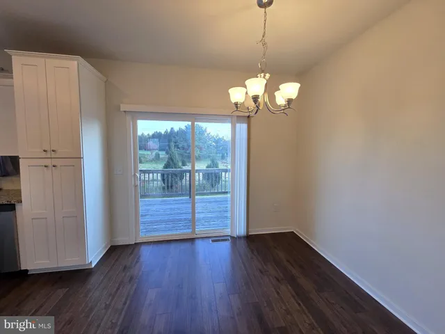 a view of a room with wooden floor closet and chandelier