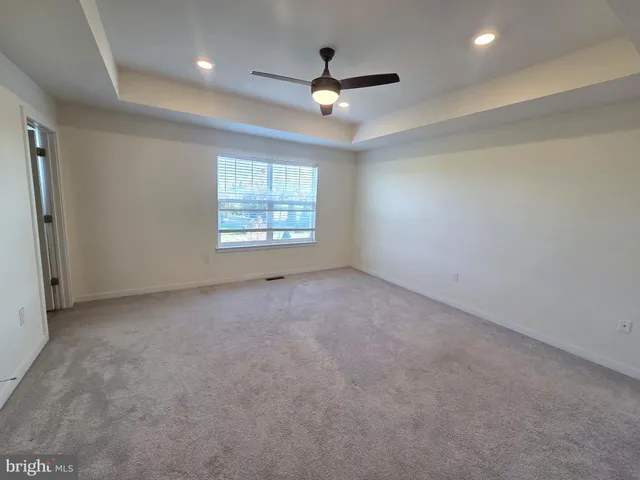 an empty room with windows and ceiling fan