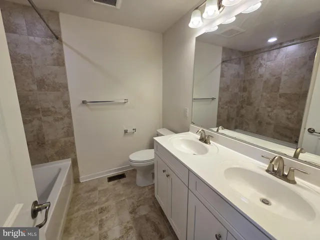 a bathroom with a sink a toilet a mirror and vanity