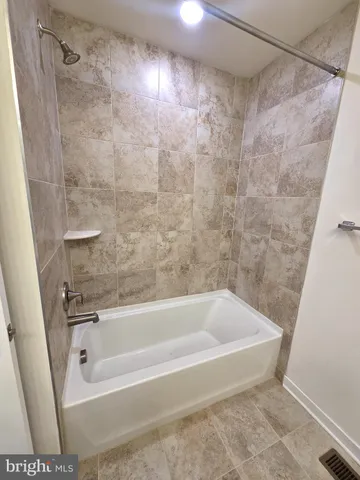 a bath tub sitting next to a white sink and vanity