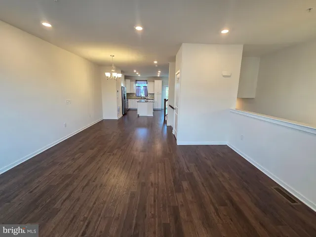 a view of a big room with wooden floor and windows