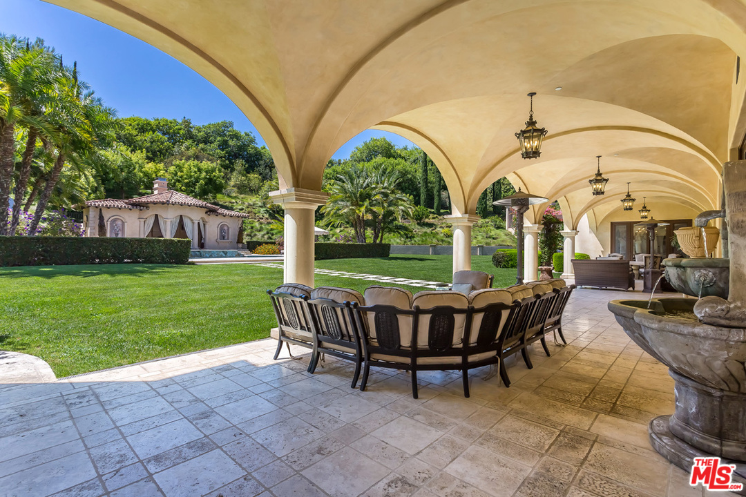 44 Beverly Park Circle Beverly Hills, CA 90210 - Photo 35 of 52 a view of a patio with a table chairs and a yard
