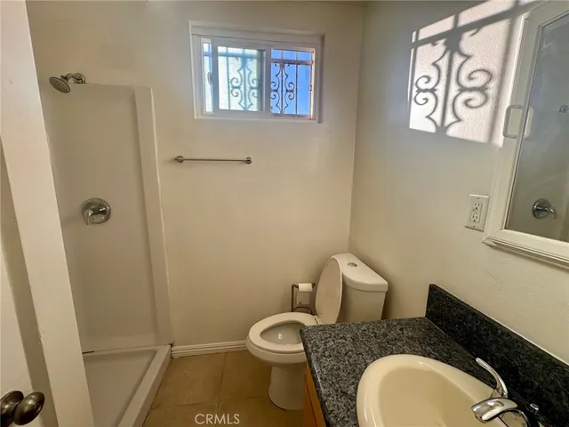 a bathroom with a granite countertop toilet and a sink