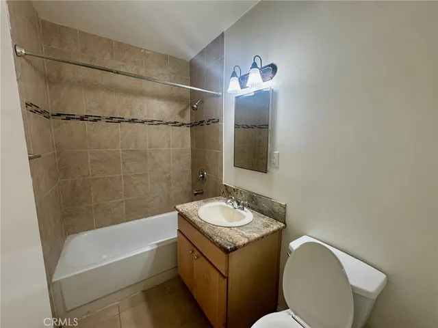 a bathroom with a granite countertop sink toilet a mirror and shower
