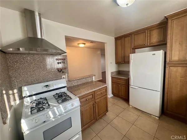 a kitchen with a stove top oven and refrigerator