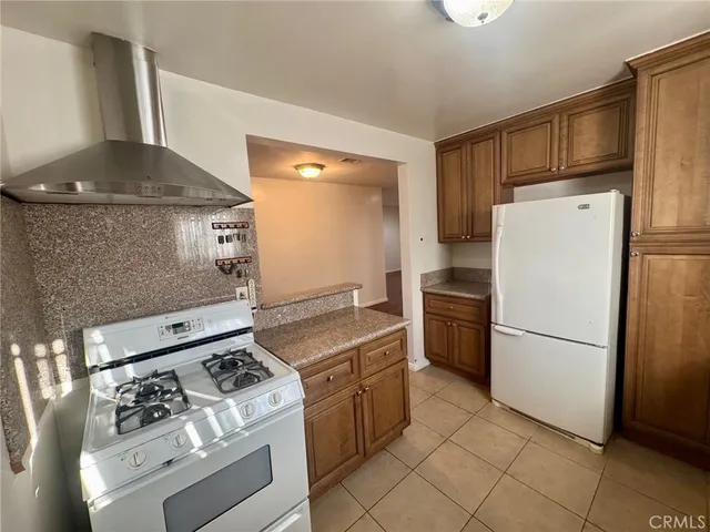 a kitchen with a stove top oven and refrigerator