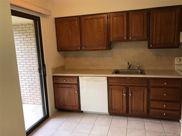 a kitchen with stainless steel appliances granite countertop wooden cabinets and a sink