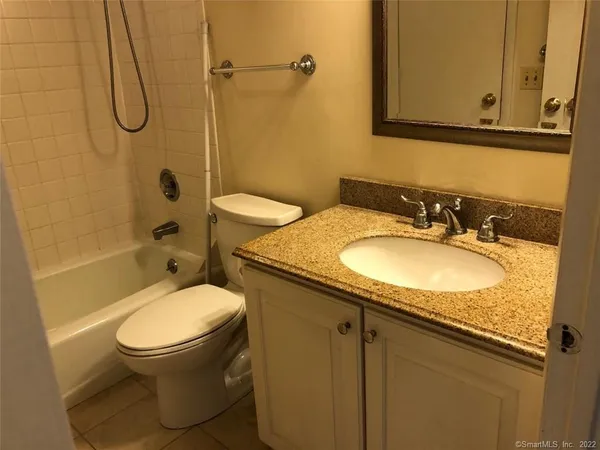 a bathroom with a granite countertop sink toilet and shower
