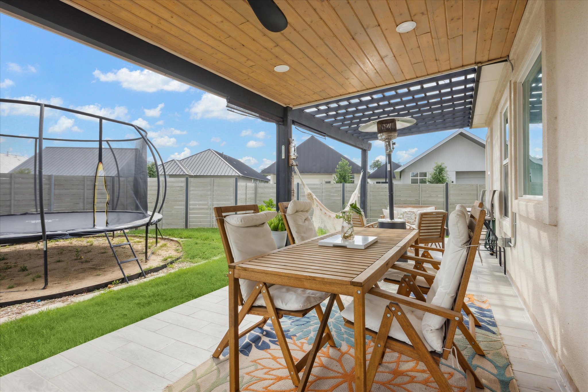 700 Legends Lane Georgetown, TX 78628 - Photo 26 of 31 Fenced backyard with a trampoline, outdoor dining space, a patio, and ceiling fan