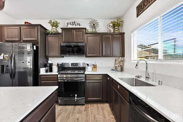a kitchen with stainless steel appliances a sink dishwasher stove and refrigerator