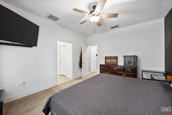 a bedroom with a bed and a flat tv screen on a dresser