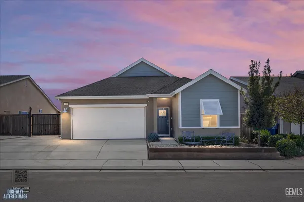 a front view of a house with a garden and garage