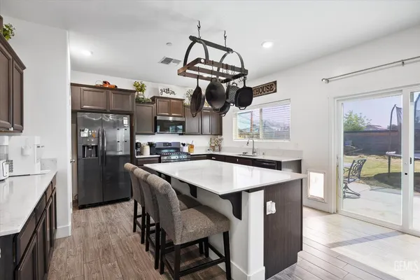 a kitchen with stainless steel appliances granite countertop a sink a stove and a refrigerator