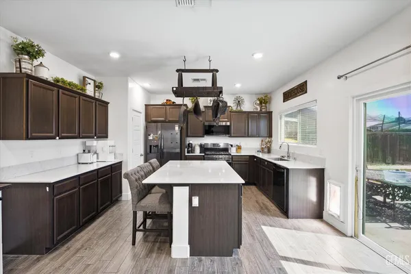 a kitchen with a sink refrigerator and cabinets