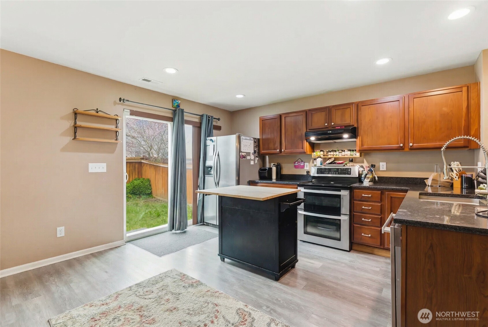 14839 99th Way Southeast Yelm, WA 98597 - Photo 7 of 31 a kitchen with kitchen island granite countertop a stove top oven a sink and a refrigerator