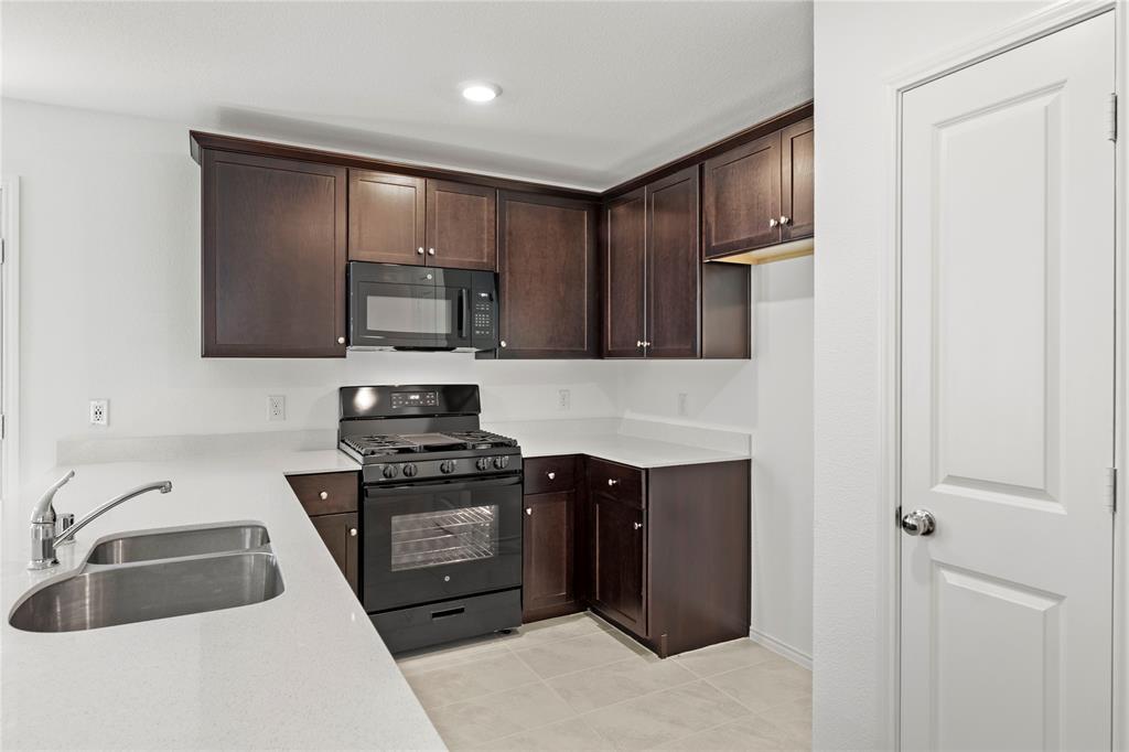 6101 Determine Forney, TX 75126 - Photo 6 of 13 a kitchen with stainless steel appliances granite countertop a sink stove and refrigerator