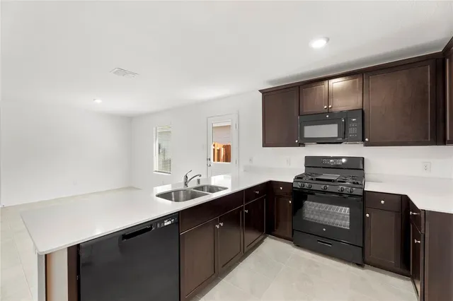 a kitchen with stainless steel appliances a sink dishwasher stove and oven