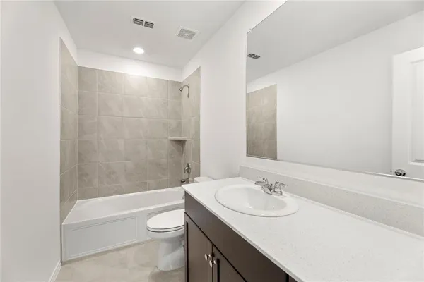a bathroom with a granite countertop sink toilet a mirror and bathtub