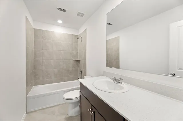 a bathroom with a granite countertop sink toilet a mirror and bathtub
