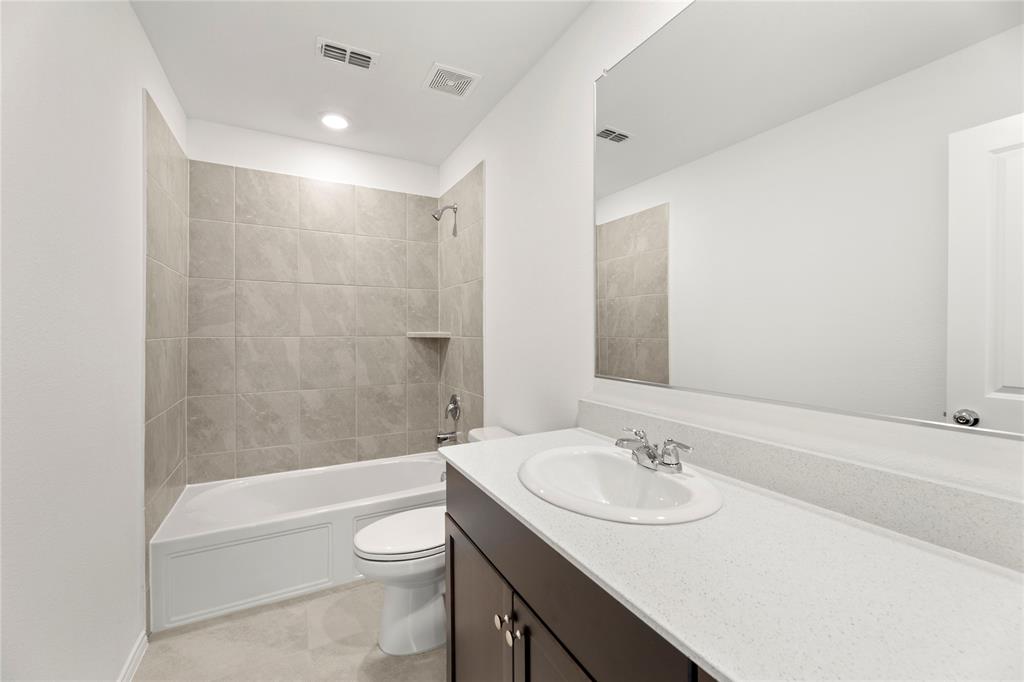 6101 Determine Forney, TX 75126 - Photo 9 of 13 a bathroom with a granite countertop sink toilet a mirror and bathtub
