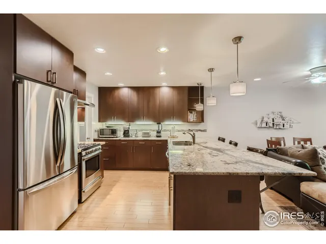 a kitchen with stainless steel appliances granite countertop a sink refrigerator and cabinets