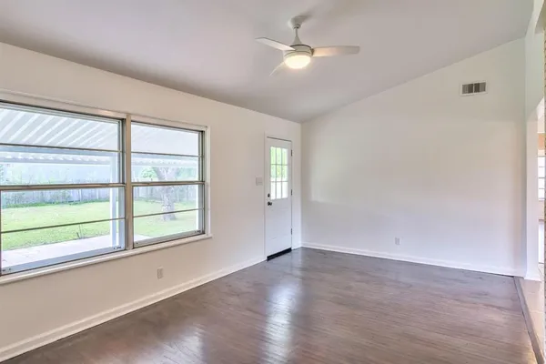 an empty room with a ceiling fan and carpet