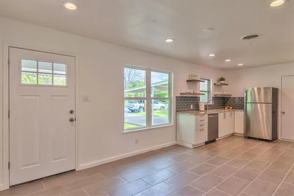 a kitchen with stainless steel appliances granite countertop a refrigerator a stove and a sink