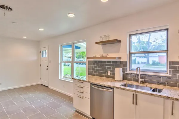 a kitchen with stainless steel appliances granite countertop a stove a sink and a microwave