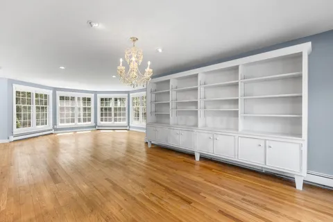 a view of empty room with wooden floor and floor to ceiling window